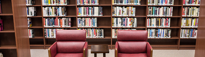 Two crimson leather chairs with a table in between at Bolivar County Library System