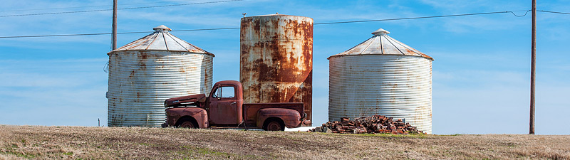 old abandoned truck against grain silos in the Mississippi delta
