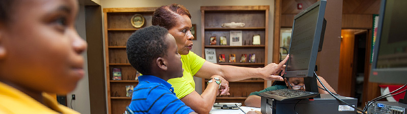 staff member instructing a child on the computer at Bolivar County Library System